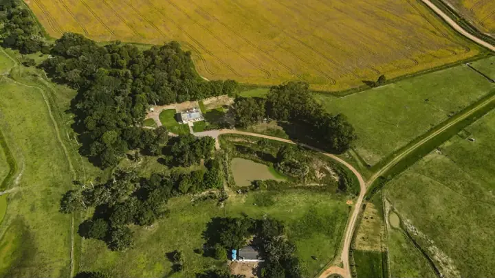 Vista aérea de lavouras, mata nativa e sede da propriedade